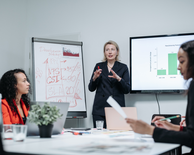 Woman standing and explaining to two seated colleagues