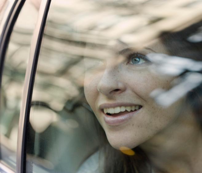 Woman watching across the window of a car