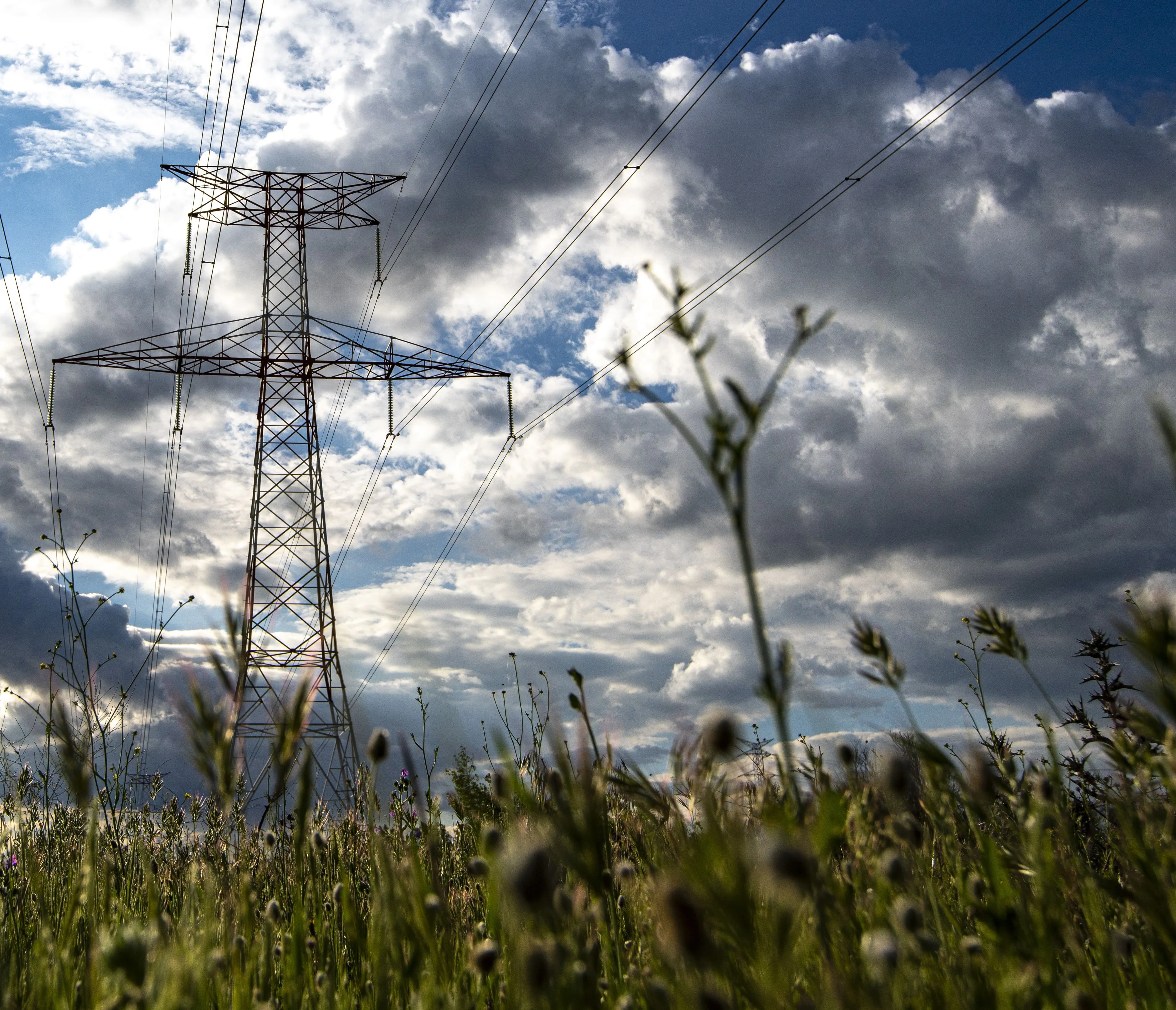 Torre eléctrica en un campo con el cielo de fondo nublado
