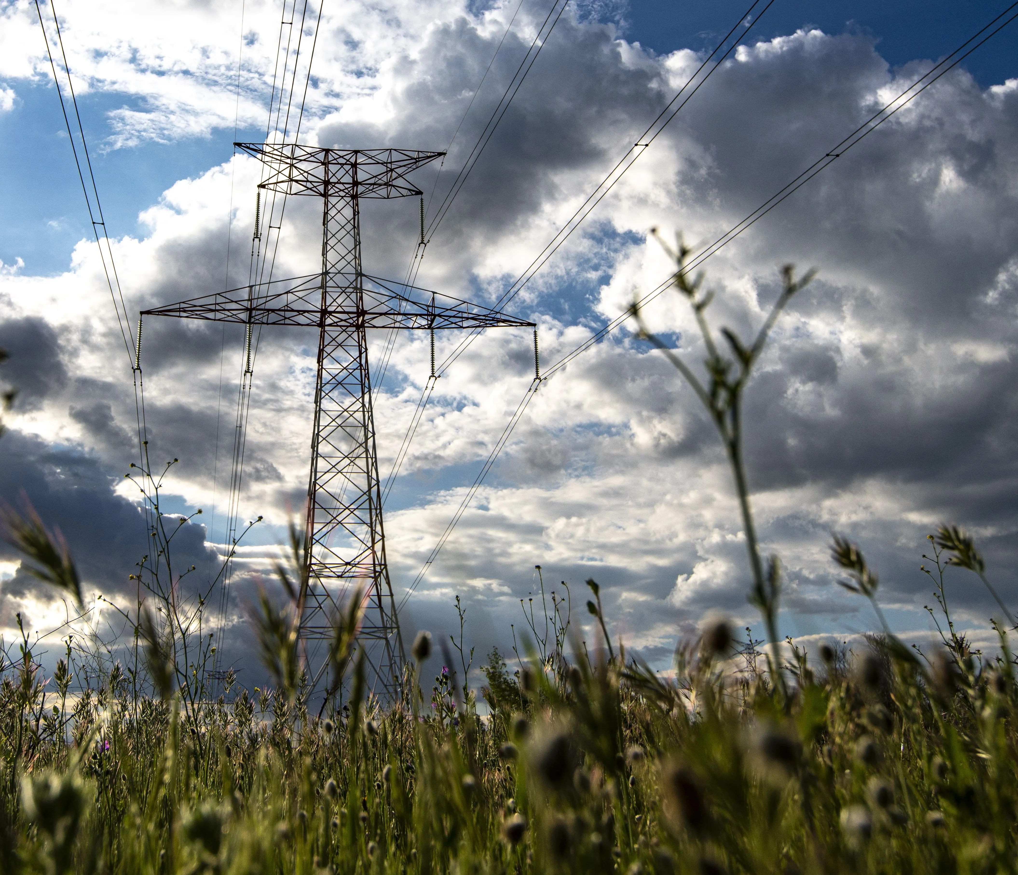 Torre eléctrica en un campo con el cielo de fondo nublado