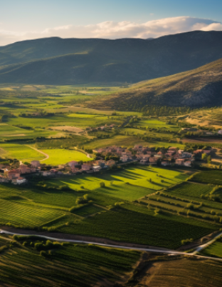 Paisaje de un pueblo rodeado de montañas y campos verdes