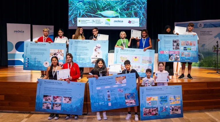 Escolares participantes en el programa Posidònia Al'Aula exponen en paneles sus proyectos de investigación sobre posidonia oceánica.