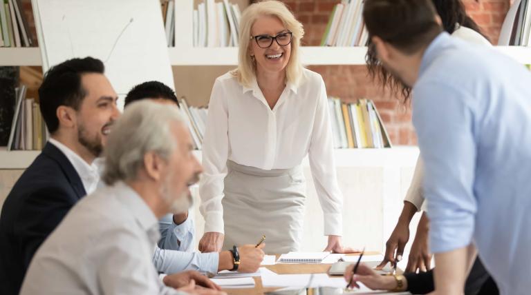 Reunión de trabajo con varias personas, varias de ellas tomando notas