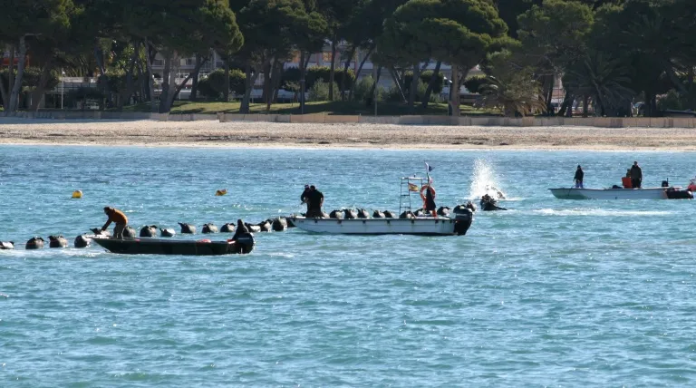 Un equipo de buzos se encarga de guiar el extremo del cable eléctrico hasta la playa de Santa Ponsa, en Mallorca, en el tendido del tercer cable submarino entre la Península y Baleares.