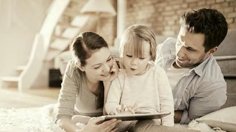 Padres viendo una Tablet junto a su hija
