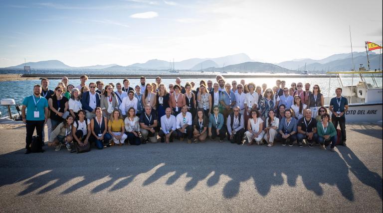 Family photo of participants in the Scientific Seminar beside Bay of Pollença (Mallorca). 