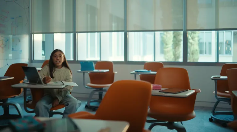 Niña sentada en un pupitre de una clase